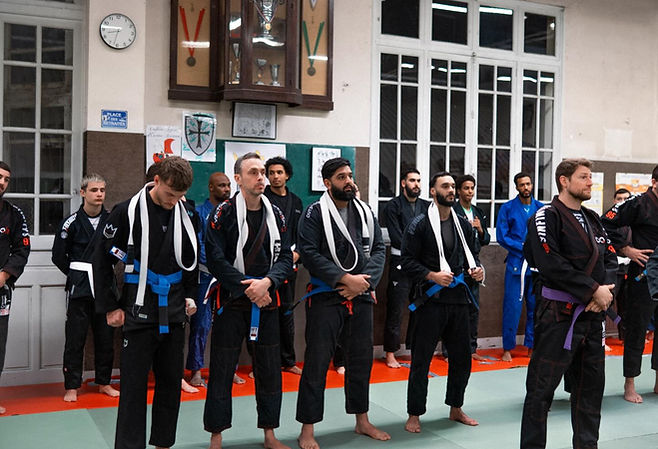 Pratiquants alignés lors d'une cérémonie de passage de grades au dojo