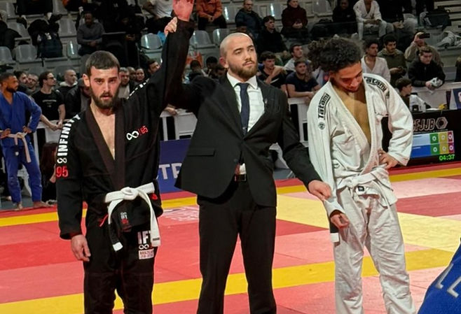 Arbitre levant le bras d'un compétiteur Infinity Combat 95 vainqueur en compétition de JJB