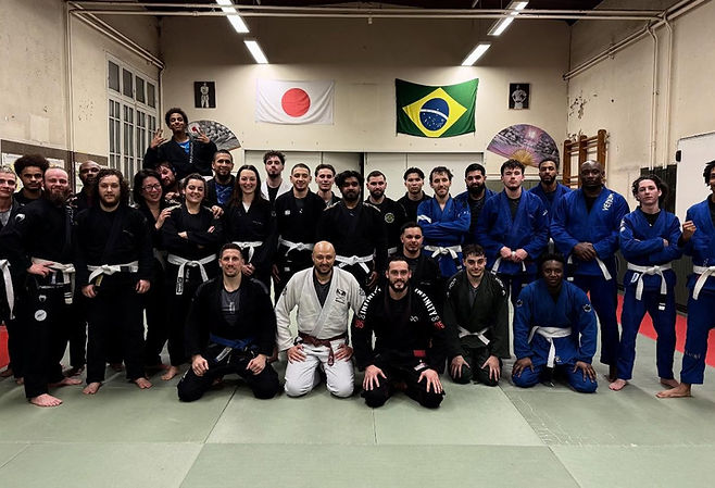 Photo de groupe des pratiquants en kimono sur le tatami, sous les drapeaux japonais et brésilien