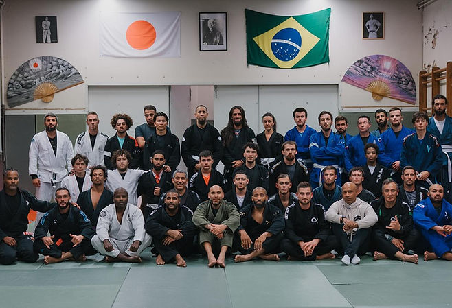 Grande photo de groupe du club en kimono et rashguard sur le tatami