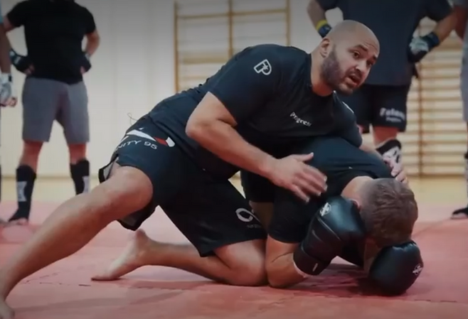 Sparring MMA au sol avec gants pendant un entraînement au dojo